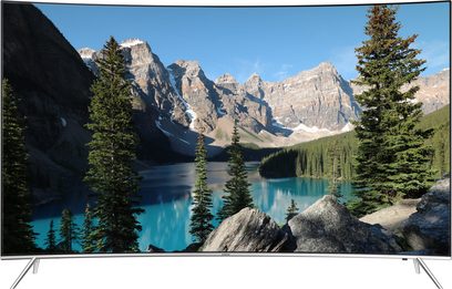 Samsung UE43KS7500 TV viser et bjerglandskab med en turkisblå sø og en nåletræsskov, set forfra