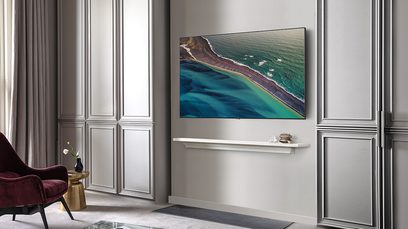 Televizor Samsung QE50Q80T 2020 zobrazující letecký pohled na pobřeží s pláží a tyrkysovou vodou v elegantním interiéru