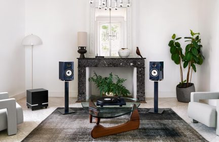 Sistem hi-fi de living cu design modern, cu două boxe de raft pe stativ, subwoofer și pick-up pe măsuța de cafea
