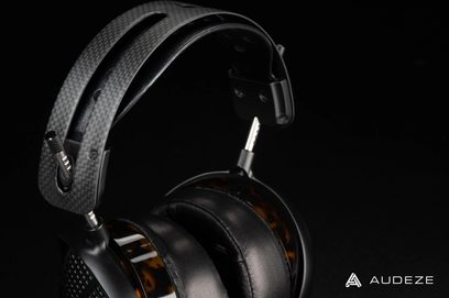Åben hi-fi hovedtelefon Audeze LCD-5, kulstofhovedbøjle og -skaller, perforeret læderpolstring, aftagelig kabel, sidevisning på sort baggrund
