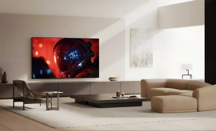 Televisor de pantalla plana montado en la pared en un salón moderno beige con imagen de un astronauta en primer plano sobre fondo rojo