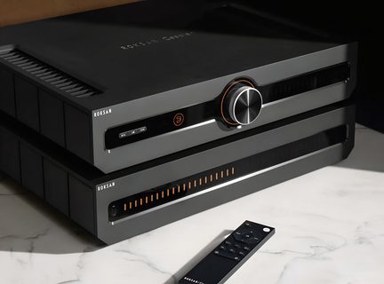 Sort Roksan hi-fi-forstærker med stor cirkulær volumenknap, orange LED-display, oven på matchende afspiller med fjernbetjening