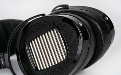 Sluchátka Hifiman Arya Unveiled s otevřenou konstrukcí, černá oválná mušle s kovovou stříbrnou mřížkou a černými koženými polstrováním