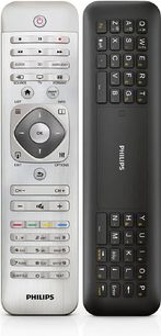 To Philips fjernbetjeninger, en grå med knapper og drejeknap, den anden sort med numerisk tastatur og funktionstaster