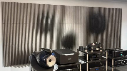 Nástěnný akustický panel se svislými lamelami v antracitově šedé barvě v hi-fi obývacím pokoji s reproduktory a gramofonem