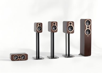 Set of five hi-fi speakers in brown walnut wood veneer, two-tone front with light wood trim around black speakers, bookshelf speakers on black tubular metal stands, front view