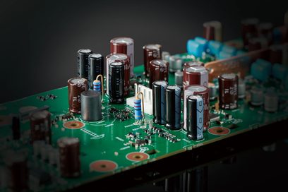 Placa de circuito impreso verde con varios condensadores electrolíticos de diferentes tamaños, Technics SL-G700M2 plateado