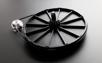 Rega Planar 1 mat witte platenspeler, bovenaanzicht van dichtbij, zwarte ronde draaitafel met zilveren centrale as