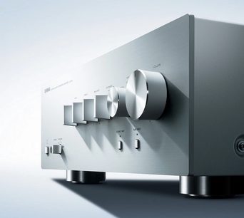 Yamaha A-S701 sidabrinės spalvos hi-fi stereo stiprintuvas, priekinis artimas vaizdas, stambiu planu matomos rankenėlės ir lizdai, šiuolaikiškas ir išvalytas dizainas