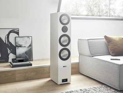 Hvid Canton Bluetooth-gulvhøjtaler med fire enheder foran grå sofa i moderne stue