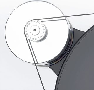 Nærbilde sett ovenfra av Transrotor Dark Star Silver Shadow RB330 hi-fi platespiller, sirkulært sølvfarget platetallerken i polert metall med perforert sentral trinse og en tynn svart rem som forbinder en delvis synlig matt svart platetallerken