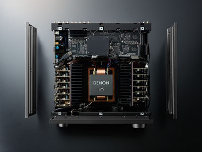 Denon AVC-A110 sort hjemmebiografsforstærker, set forfra med åbent kabinet, hvor de elektroniske kredsløb og komponenter er synlige