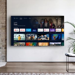 TCL 75C721-fjernsyn, der viser Google Play-grænsefladen med miniaturebilleder af videostreamingtjenester på en murstensvæg