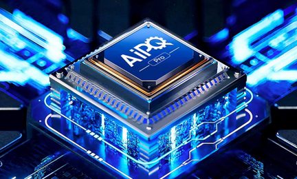 Microprocessore quadrato in metallo blu con la scritta «AiPQ Pro», circondato da un bordo dorato e montato su una base argentata attraversata da circuiti stampati illuminati da luce blu, visto leggermente dall’alto