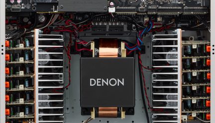 Внутрішній вигляд підсилювача Denon, центральний чорний трансформатор, червоні та сині кабелі, металеві радіатори