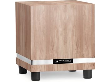 Triangle Thetis 340 subwoofer i lys eik, kubeformet kabinett i lyst eiketre med naturlig åremønster, sølvfarget metallbånd ved basen og fire svarte sylindriske ben, sett fra trekvart vinkel foran