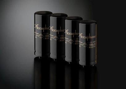 Accuphase C-2300, cuatro cilindros negros verticales, inscripciones doradas, superficie reflectante, fondo gris oscuro