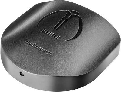 Audioquest Beetle sort DAC-konverter, tæt ovenfra-billede, flad cylindrisk form med indgraveret logo