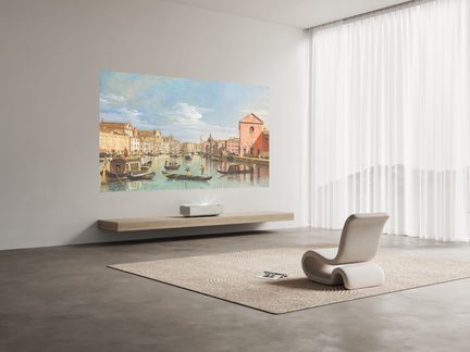 Moderni salė su pilka siena, Venecijos paveikslu, medine lentyna, projektoriumi, dizaino kėde, smėlio spalvos kilimu, baltais užuolaidomis