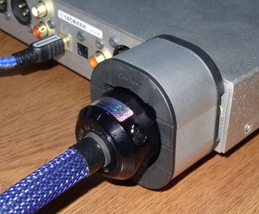 Furutech NCF Booster Brace Single i grått metall, blå kontakt, blått flettet kabel, sidevisning på trebord