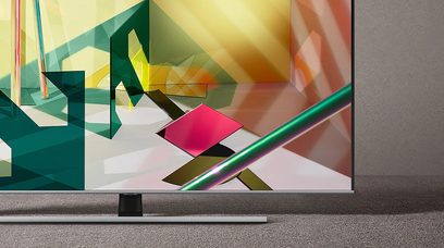 Tv-scherm dat een kleurrijke abstracte afbeelding met hoekige geometrische vormen weergeeft op een meubel voor een grijze muur