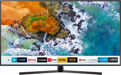 Samsung UE50NU7475-TV som viser en scene med turkise bølger som bryter over mørke klipper