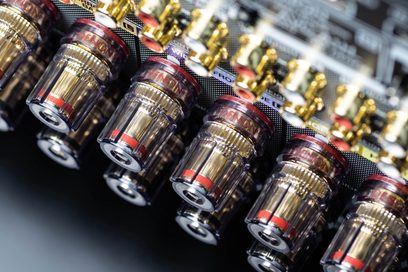 Connettori audio RCA dorati e neri allineati su un pannello posteriore in metallo nero di un dispositivo elettronico Denon AVC-A1H