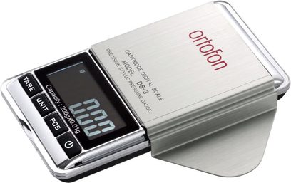 Digitální váha Ortofon DS-3 v kovovém stříbrném provedení, LCD displej zobrazující 111.0, tři tlačítka na pravé straně