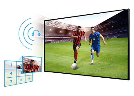 Twee voetballers in actie op een veld, één in rood en zwart, de ander in blauw, met een witte bal op de grond