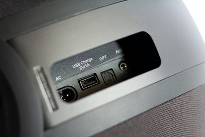 Frontvue af den trådløse, tilsluttede Elipson Planet W35+ højttaler, USB- og optiske porte, tænd/sluk-knap på siden