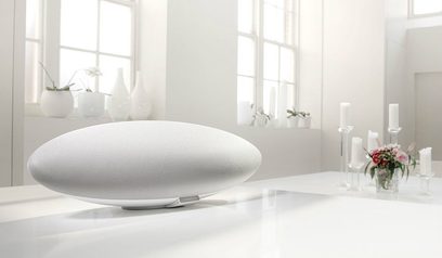 Bowers & Wilkins' trådløse Zeppelin Wireless højttaler i hvid, set forfra, placeret på et hvidt bord i et lyst interiør