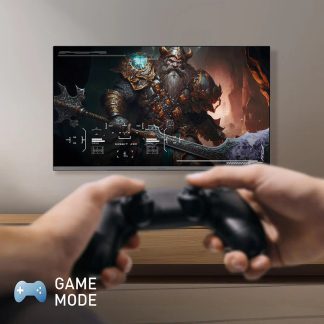 Fladskærm på væggen viser et videospil med en skægget karakter i rustning, hænder holder en sort controller i forgrunden
