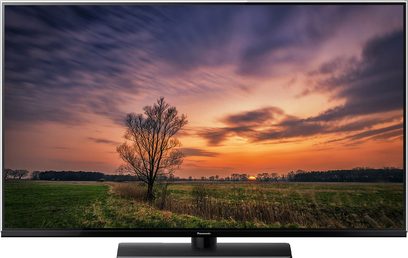 Panasonic TX-55FX740 fladskærms-TV, der viser et landskab med en mark ved solnedgang med et enkelt træ i forgrunden