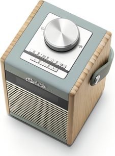 Radio da tavolo Roberts Rambler Midi color cielo con pannelli laterali in legno chiaro, rivestimento superiore blu anatra dotato di un ampio pulsante metallico e tasti rettangolari, maniglia laterale coordinata e frontale anteriore con griglia perforata color crema, vista in tre quarti dall'alto