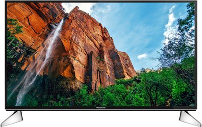 Panasonic TX-55EX600E-fladskærm, der viser en orange klippefyldt kløft med et vandfald og vegetation, set forfra