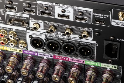Pannello posteriore dell'amplificatore home theater Denon AVC-A1H color argento con numerose prese audio/video, vista ravvicinata