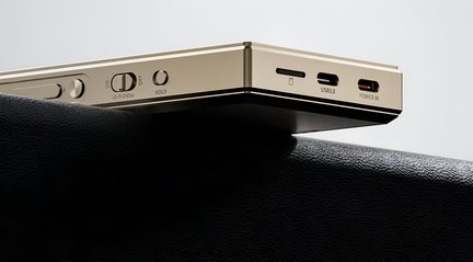 Zlati kovinski pravokotni elektronski naprave, stranski pogled v povečavi, opremljen z drsnim stikalom, krožnim gumbom, vrezom za kartico in dvema USB vhodoma