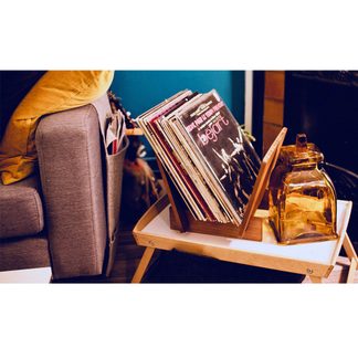 Stak vinylplader i en trækasse, glaskrukke og vintage-dekoration på et sofabord