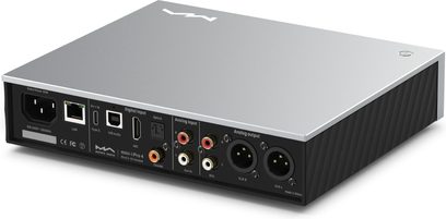Matrix Audio Mini‑i Pro 4 sudraba alumīnija tīkla audio atskaņotājs, trīs ceturtdaļu aizmugures skats, plakans korpuss no matēta metāla ar rievotām melnām sānu malām un pilnīgu aizmugurējo pieslēgvietu klāstu, tostarp IEC ligzda, RJ45 ports, USB‑C, optiskās un koaksiālās ieejas, RCA pāri un XLR izejas