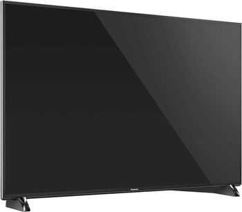 Téléviseur Panasonic TX-58DX900E à écran plat noir, vue de face, éteint, sur pied métallique