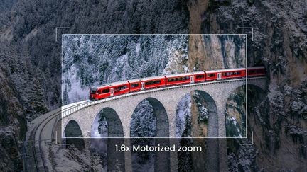 Vörös, többkocsis vonat egy kőíves viadukton hóborította erdőben, felülről nézve, 1.6x motoros zoommal