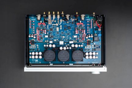 Viršutinis vaizdas į spausdintinę plokštę su elektroniniais komponentais, kondensatoriais, jungtimis, laidais, juodu korpusu