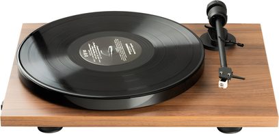 Πικάπ hi-fi Pro-Ject E1 BT AT3600L με μαύρο κυκλικό πλατό, μαύρο βραχίονα ανάγνωσης και ορθογώνια βάση με φινίρισμα καρυδιάς.