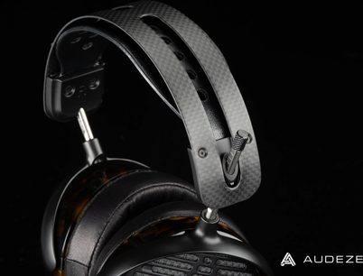 Audeze LCD-5 hovedtelefoner i sort og sølv, set fra venstre profil, hovedbånd og ørepuder i læder, gitter i kulfiber