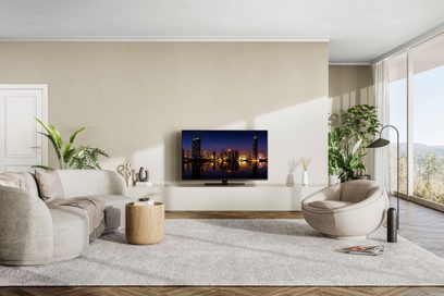Televizor Panasonic TX-48MZ1500E zobrazující osvětlené město v noci, umístěný na nízkém nábytku v moderním obývacím pokoji