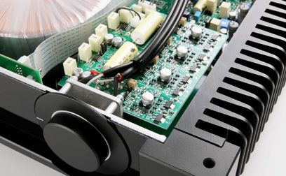 Ampli hi-fi stéréo Rega Aethos Noir, vue intérieure composants électroniques sur circuit imprimé vert et radiateur noir