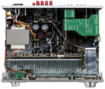 Inre vy av en öppen Denon AVR-1910 hembioanläggning, som visar kretskort, elektroniska komponenter och kylfläns