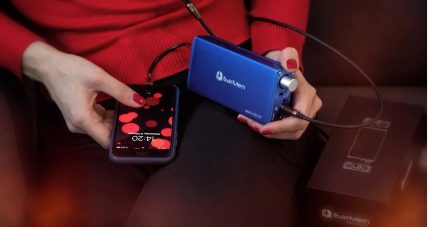 Amplificatore per cuffie DAC portatile EarMen Angel blu collegato a uno smartphone e a una cuffia