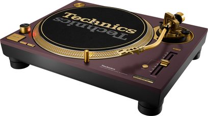 Technics SL-1200M7G vinylplatespiller i burgunderrød, svart tallerken og gullfarget tonearm, sett fra trekvart vinkel