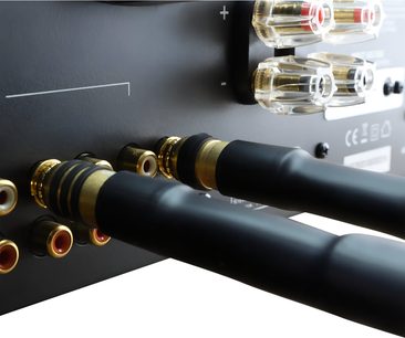 Analogový audio kabel Oehlbach Series 1 RCA, černý měkký PVC plášť, pozlacené kovové konektory s černým kroužkem, detailní pohled zezadu při zapojování do RCA konektorů zařízení